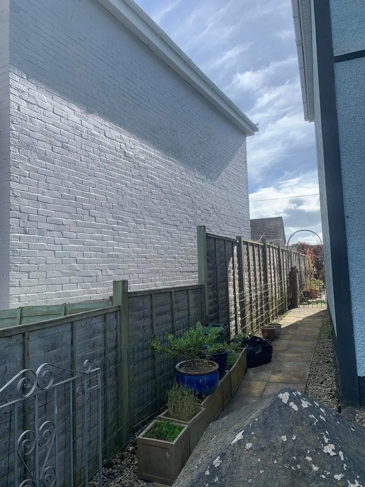 Freshly painted brick wall after preparation and masonry paint in Carn Brea